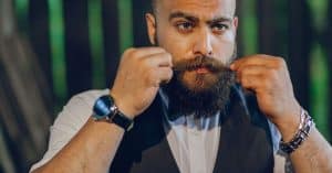 Man met baard styled zijn snor met baardwax